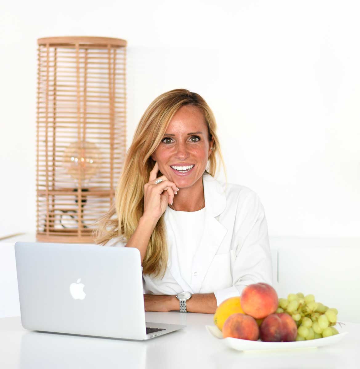 A treinadora está posando com seu laptop.